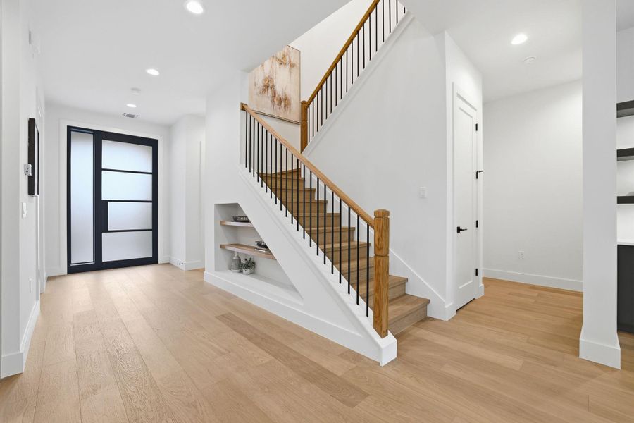 Entryway with light wood finished floors and recessed lighting