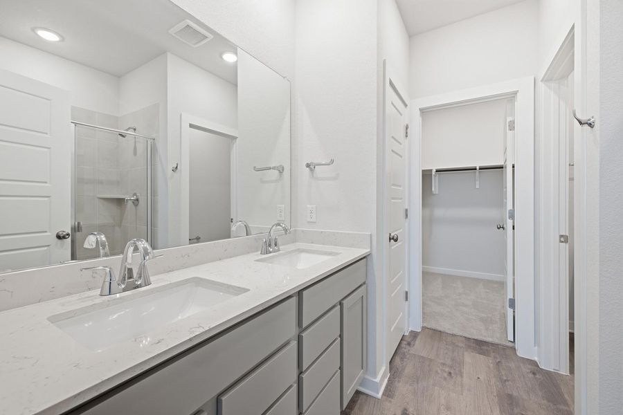 Dual vanity with sleek fixtures offers ample space and a stylish design.