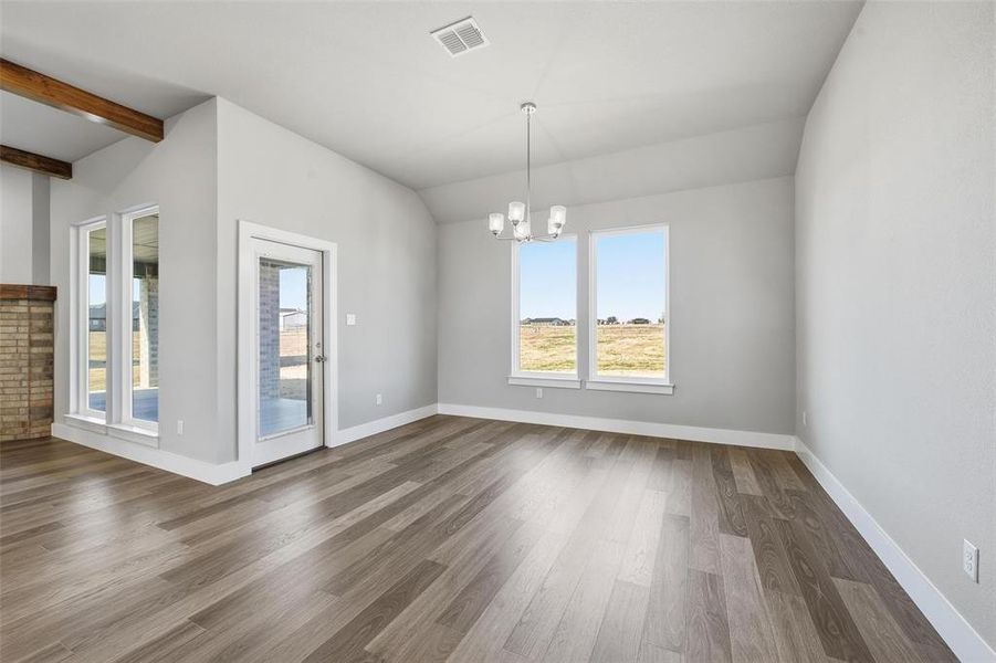 Unfurnished room featuring a chandelier and wood finished floors