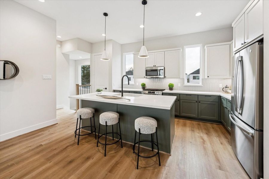 Anchored by two stylish pendants, the kitchen provides abundant counter space perfect for preparing and sharing your favorite meals.