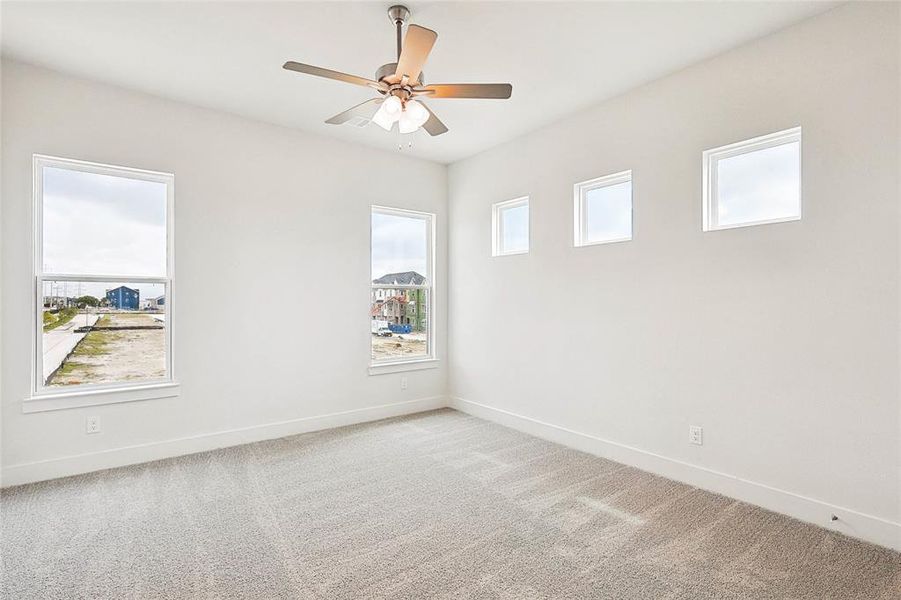 Carpeted spare room with ceiling fan