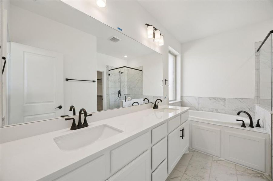 Bathroom with a marble finish shower, double vanity, a garden tub, and light marble finish flooring Bathroom with a marble finish shower, double vanity, a garden tub, and light marble finish flooring