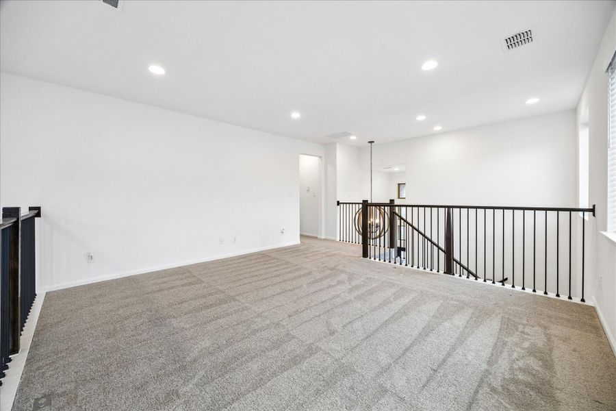 This spacious upstairs game room gives everyone room to spread out, relax, and enjoy their own space. With balcony overlooks on both sides, it stays connected to the heart of the home while creating the perfect spot for game nights, movie marathons, or a laid-back lounge.