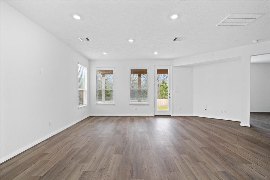 Gather the family and guests together in your lovely family room! Featuring high ceilings, recessed lighting, custom paint, gorgeous vinyl plank floors, large windows with blinds, and an access door to the covered patio and backyard. Gather the family and guests together in your lovely family room! Featuring high ceilings, recessed lighting, custom paint, gorgeous vinyl plank floors, large windows with blinds, and an access door to the covered patio and backyard.