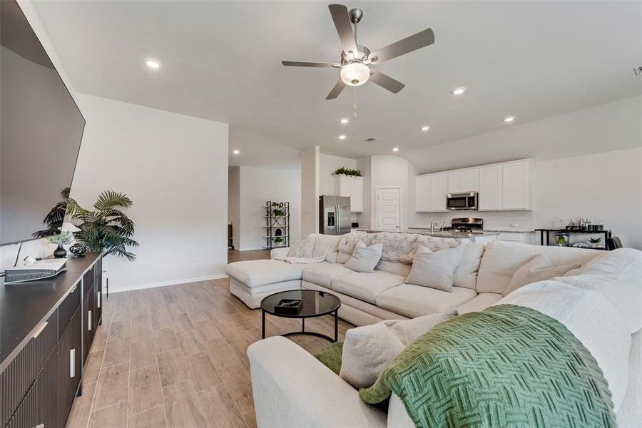 Living room featuring wood finish floors, recessed lighting, and ceiling fan Living room featuring wood finish floors, recessed lighting, and ceiling fan