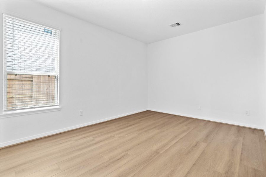 Tucked peacefully at the front of the home, this Den offers a quiet workspace with vinyl plank flooring, high ceilings, recessed lighting, large window with blinds, and custom paint for a polished finish.