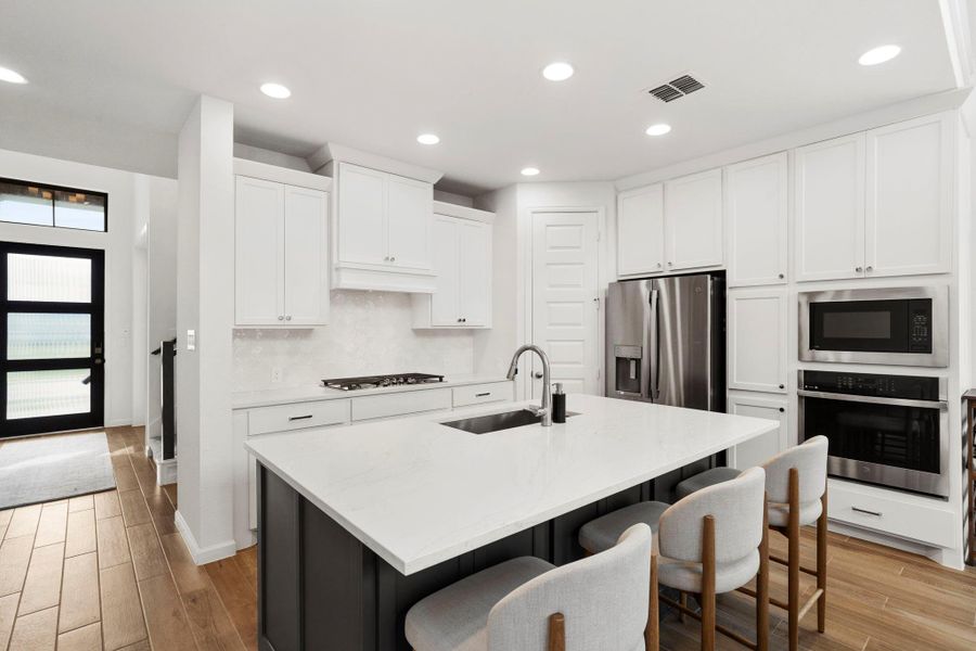 Modern kitchen equipped with premium stainless steel appliances, a gas cooktop, and abundant cabinetry for storage. Modern kitchen equipped with premium stainless steel appliances, a gas cooktop, and abundant cabinetry for storage.