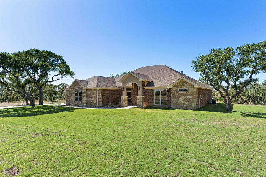 View of front of property featuring a front yard, brick siding, and roof with shingles View of front of property featuring a front yard, brick siding, and roof with shingles