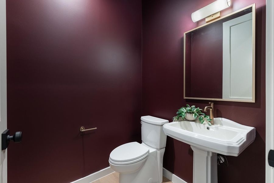 Half bath featuring toilet and baseboards