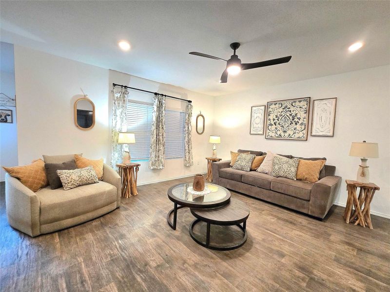 Spacious living area featuring wood-finish flooring, recessed lighting, and a ceiling fan