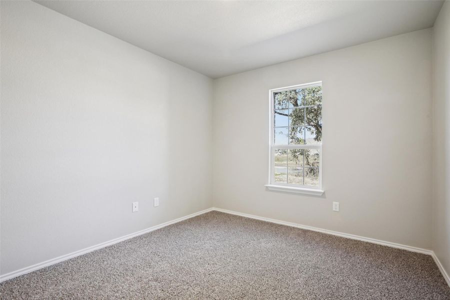 Carpeted empty room featuring baseboards