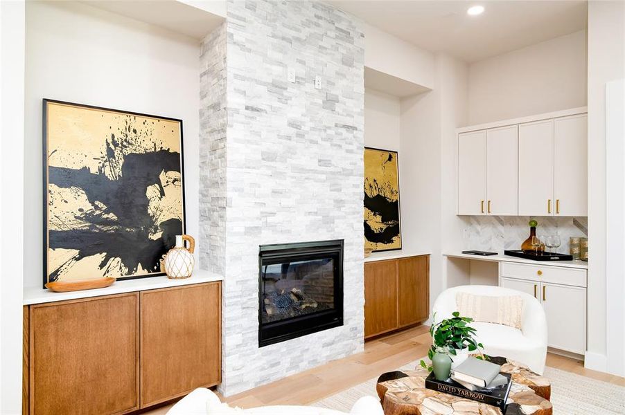 Living room with a fireplace and light wood-type flooring