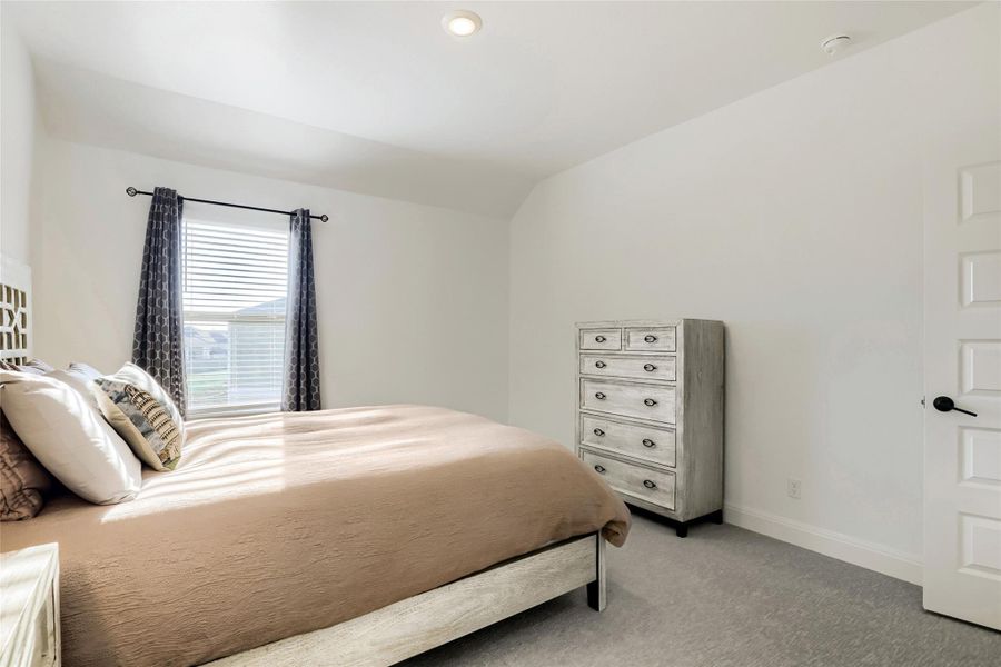A well-lit bedroom with comfortable carpeting offers a tranquil retreat. A well-lit bedroom with comfortable carpeting offers a tranquil retreat.