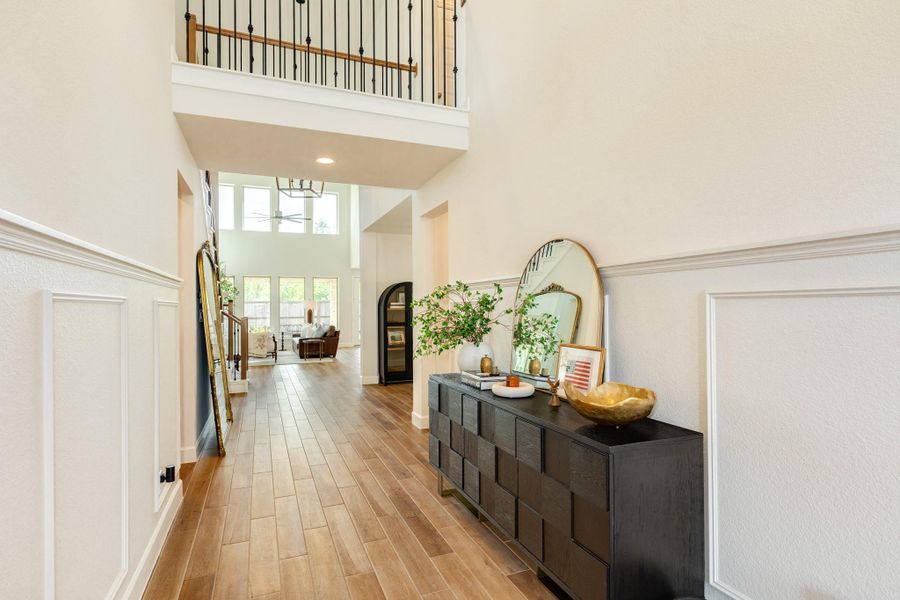 Elegant front entrance featuring a grand sightline stretching through the home, past the family room, and out to the backyard. To the right, a private guest suite with an en-suite bath offers comfort for visitors, while the left side of the foyer conveniently accesses the laundry room, mudroom, and attached garage. Elegant front entrance featuring a grand sightline stretching through the home, past the family room, and out to the backyard. To the right, a private guest suite with an en-suite bath offers comfort for visitors, while the left side of the foyer conveniently accesses the laundry room, mudroom, and attached garage.
