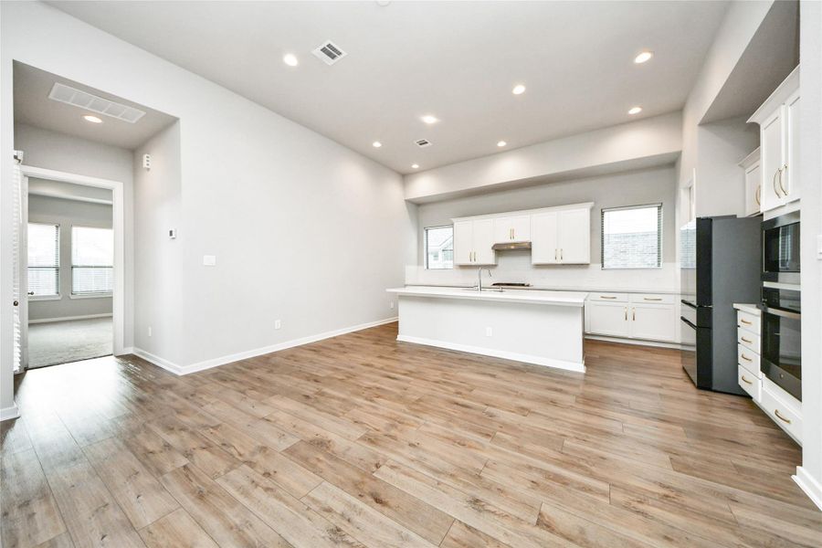 Wide view of kitchen and living room with seamless entertaining layout