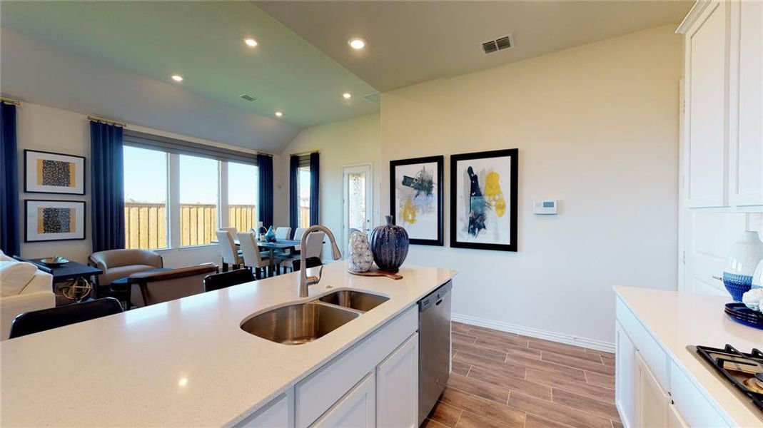 Kitchen featuring white cabinets, open floor plan, wood tiled floors, recessed lighting, and stainless steel appliances