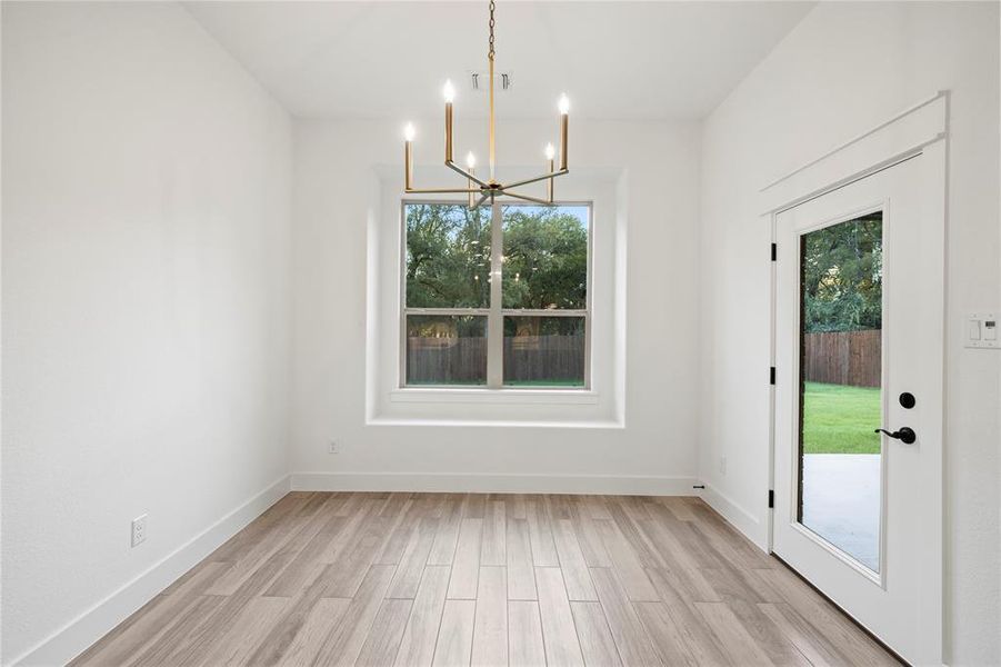 Unfurnished dining area with light wood finished floors and a chandelier