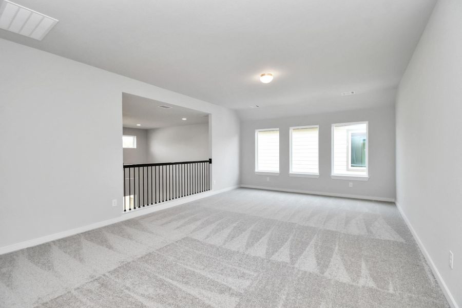 Come upstairs and relish a day of relaxation in this loft area! Ideal as an additional living space or game room, it boasts plush carpeting, high ceilings, custom paint, and windows that flood the area with abundant natural light. Come upstairs and relish a day of relaxation in this loft area! Ideal as an additional living space or game room, it boasts plush carpeting, high ceilings, custom paint, and windows that flood the area with abundant natural light.