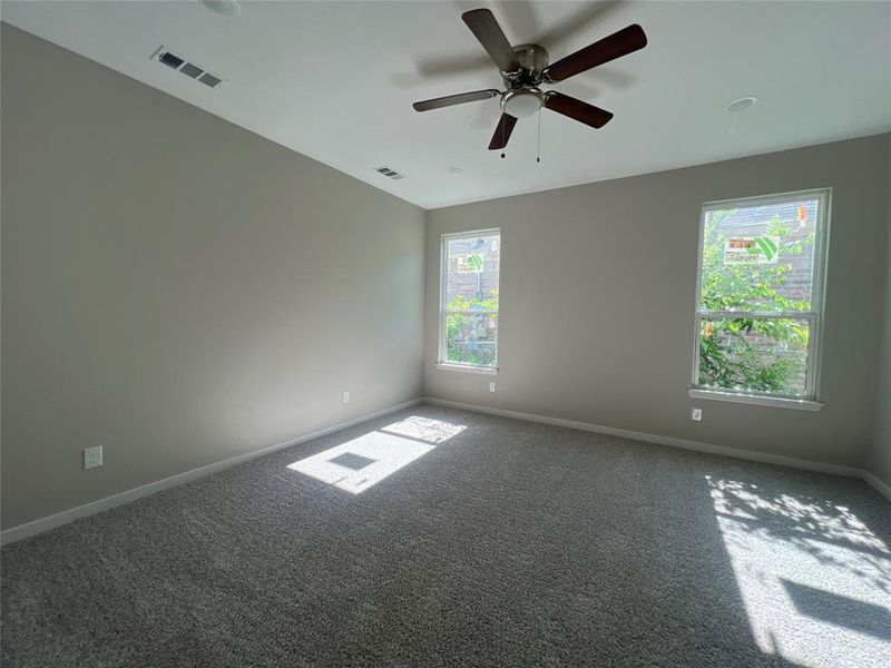 Carpeted spare room featuring ceiling fan