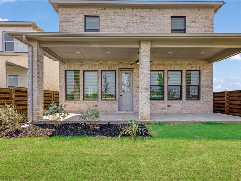 Rear view of house featuring brick siding, ceiling fan, and a patio area Rear view of house featuring brick siding, ceiling fan, and a patio area