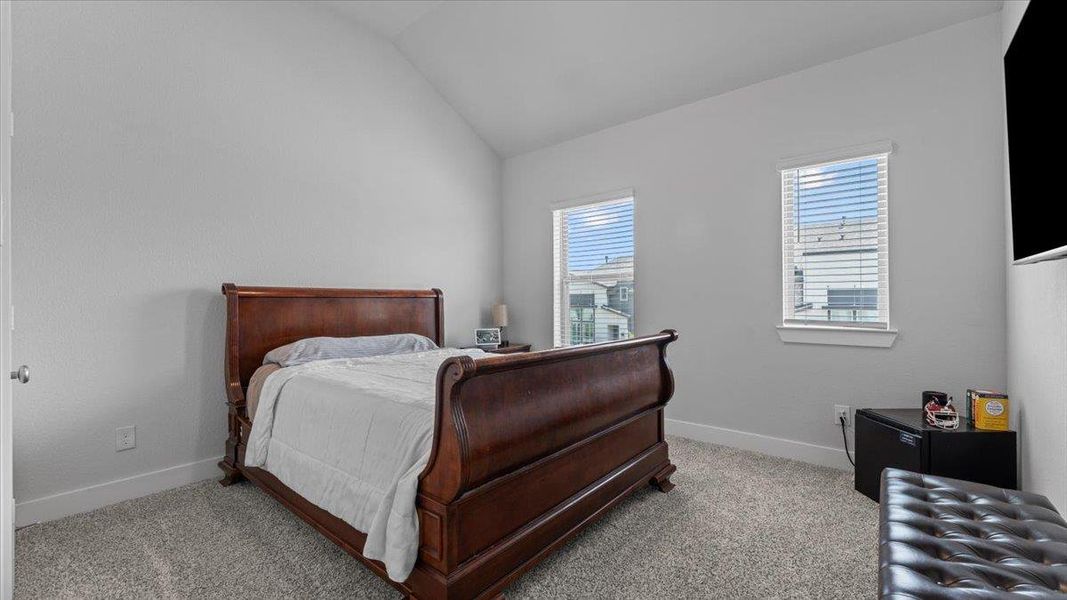 Bedroom featuring vaulted ceiling and carpet Bedroom featuring vaulted ceiling and carpet