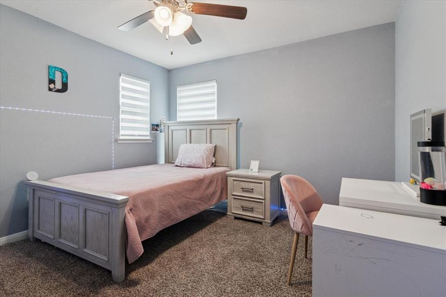 Bedroom featuring dark carpet and a ceiling fan Bedroom featuring dark carpet and a ceiling fan