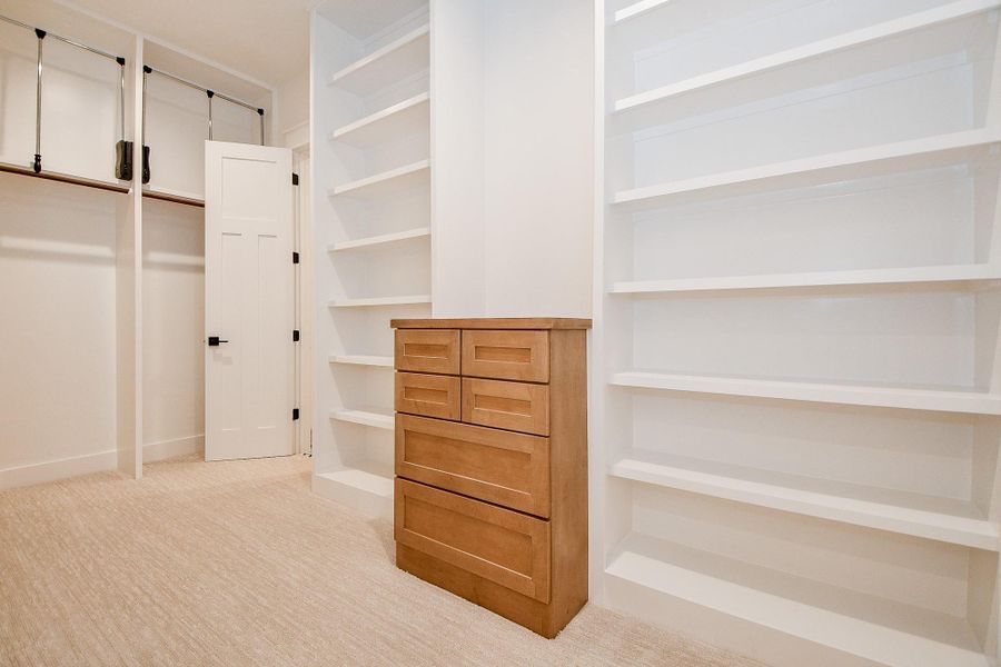 This expansive walk-in closet is both beautiful and functional, featuring custom built-ins, open shelving, and ample space for wardrobe organization. It seamlessly connects to the primary bathroom for convenience and flow. This expansive walk-in closet is both beautiful and functional, featuring custom built-ins, open shelving, and ample space for wardrobe organization. It seamlessly connects to the primary bathroom for convenience and flow.