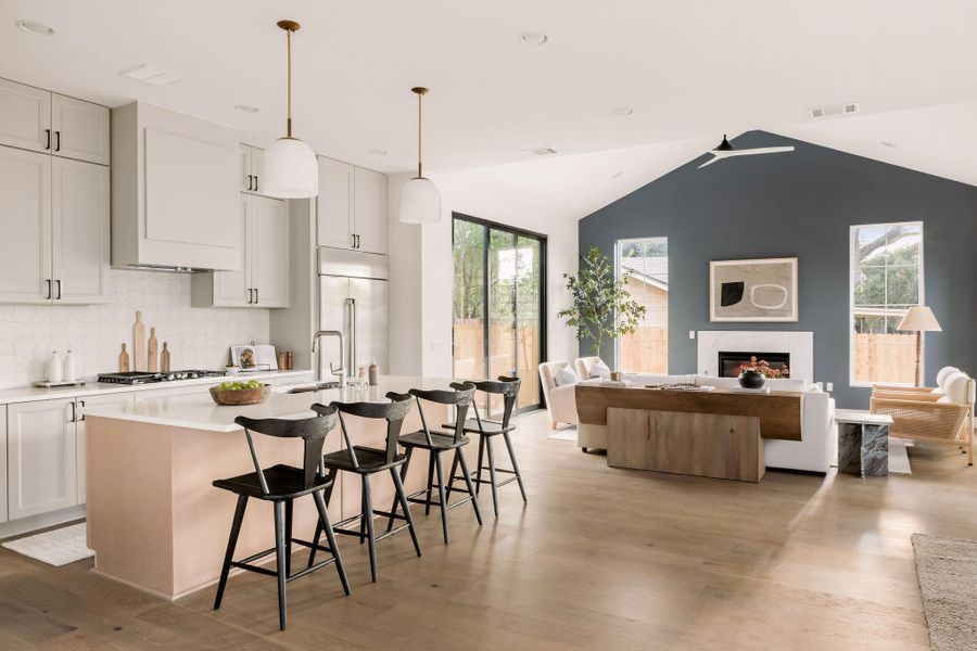 Kitchen featuring open floor plan, a breakfast bar area, lofted ceiling, a center island with sink, and backsplash Kitchen featuring open floor plan, a breakfast bar area, lofted ceiling, a center island with sink, and backsplash