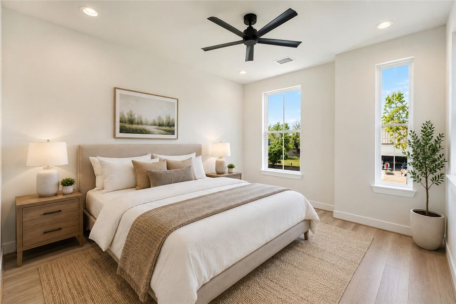 Bright secondary bedroom with large windows and modern finishes.