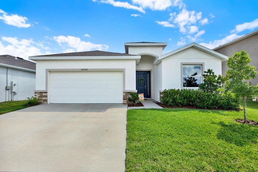 Front exterior of a new home in Woodcreek, Wesley Chapel, FL, highlighting curb appeal (Image 26).