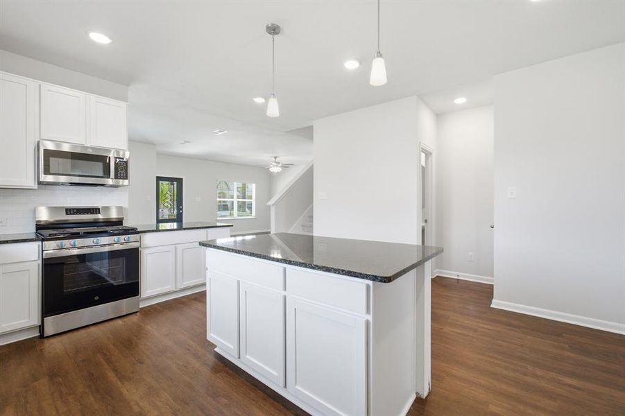 Kitchen island with a dark countertop and white cabinetry