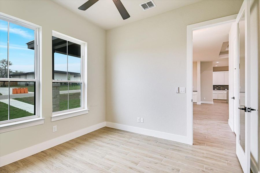 Empty room with light wood-type flooring and a ceiling fan