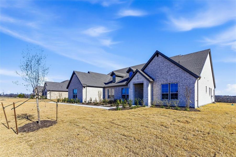 View of front of property featuring a front yard and brick siding