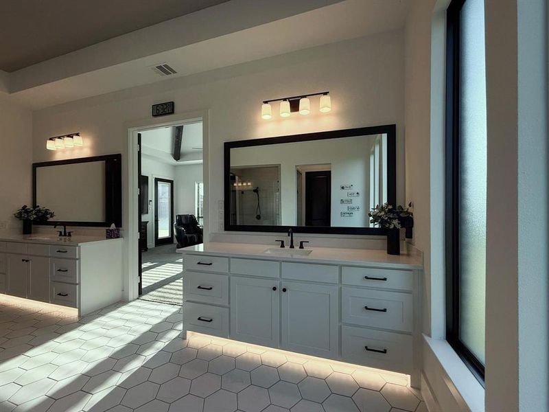 Full bathroom with two vanities, a stall shower, and light tile patterned floors Full bathroom with two vanities, a stall shower, and light tile patterned floors