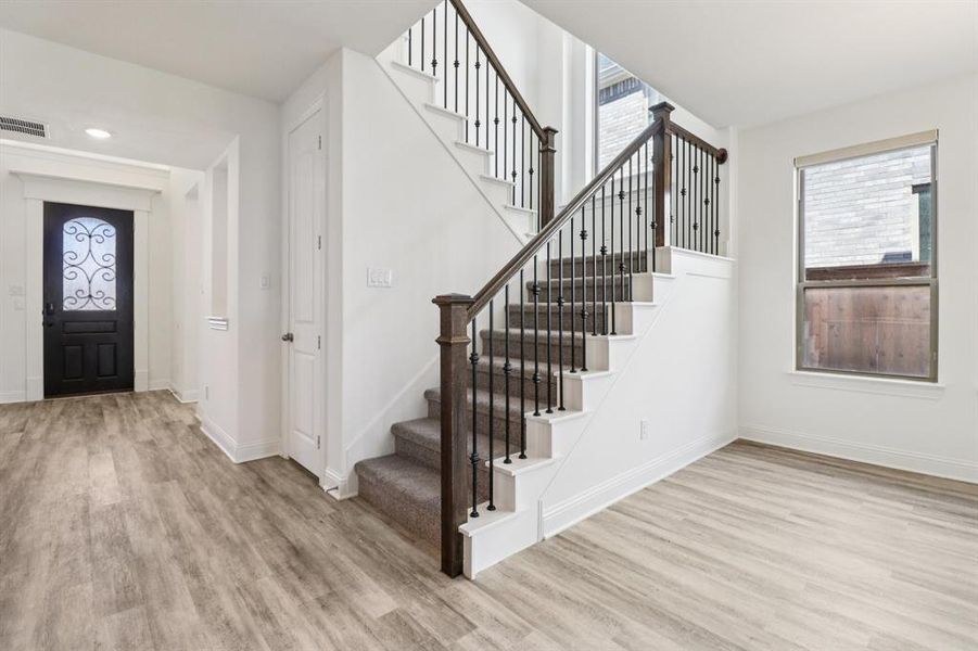 Entryway with light wood-style flooring and stairs Entryway with light wood-style flooring and stairs