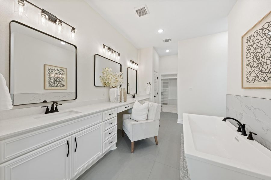 Bathroom featuring vanity, a freestanding bath, light tile patterned floors, recessed lighting, and a walk in closet Bathroom featuring vanity, a freestanding bath, light tile patterned floors, recessed lighting, and a walk in closet