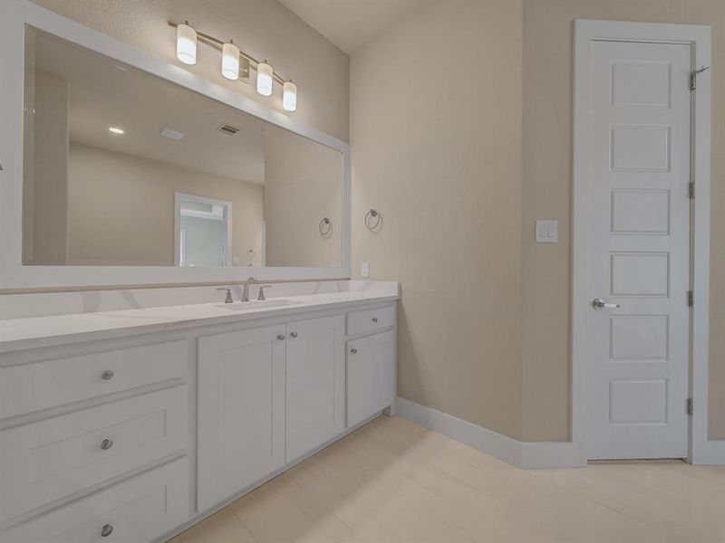 Bathroom featuring vanity and baseboards Bathroom featuring vanity and baseboards