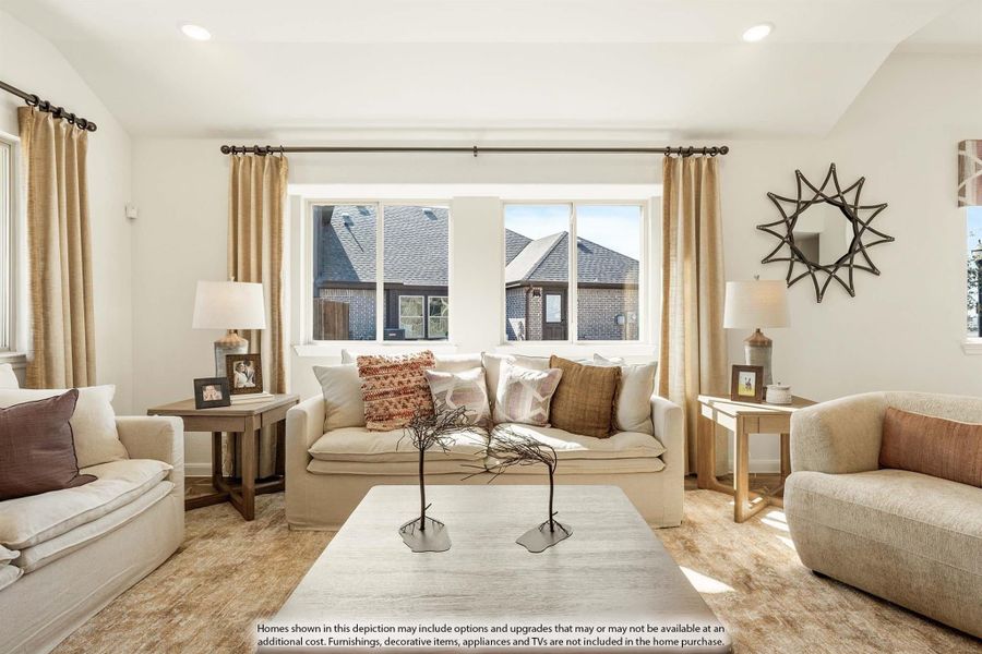 Living room with cream sofa, neutral area rug, large windows, and decorative curtains in warm tones