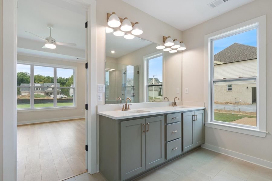 Double vanity with dual sinks, quartz countertop, and integrated wall mirror Double vanity with dual sinks, quartz countertop, and integrated wall mirror