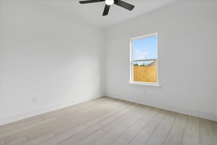 Empty room featuring light hardwood / wood-style flooring and ceiling fan