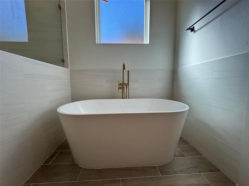 Bathroom featuring tile walls and a tub