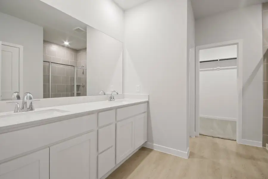 A bathroom with white cabinets.