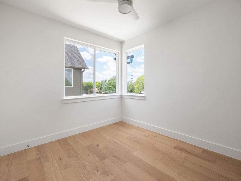 Hardwood floors and generous window space define this bright, versatile room.