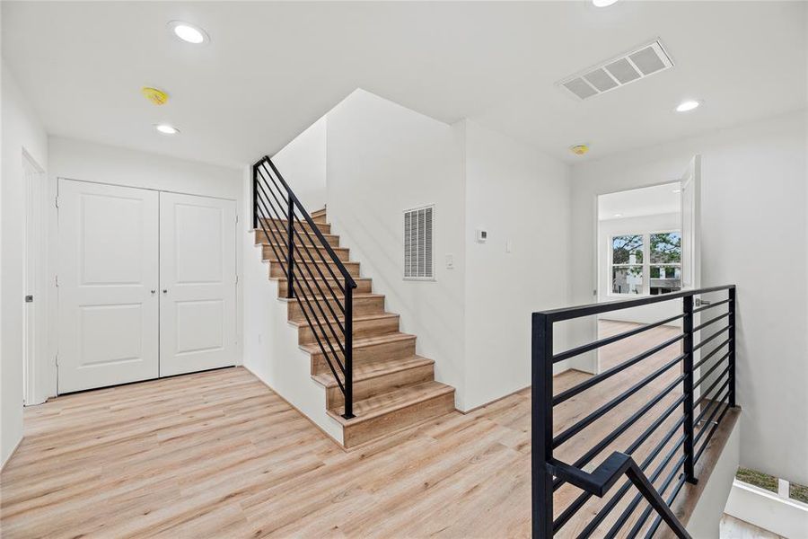 Clean, modern staircase rails blend perfectly with the Luxury Vinyl plank flooring.