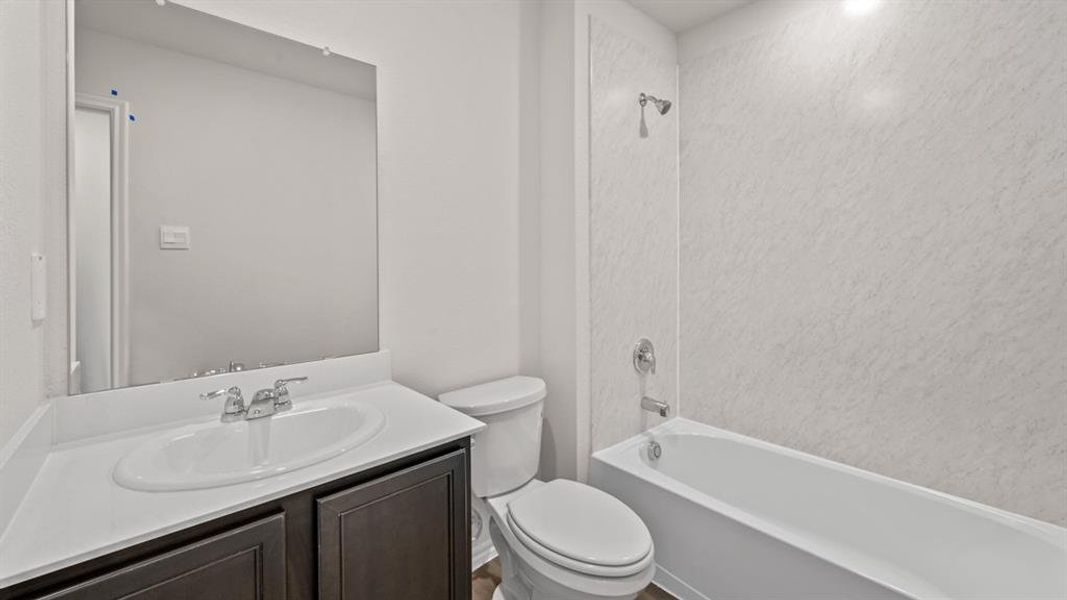 Bathroom featuring a vanity with dark wood-finish cabinetry, a white countertop, and a white oval undermount sink