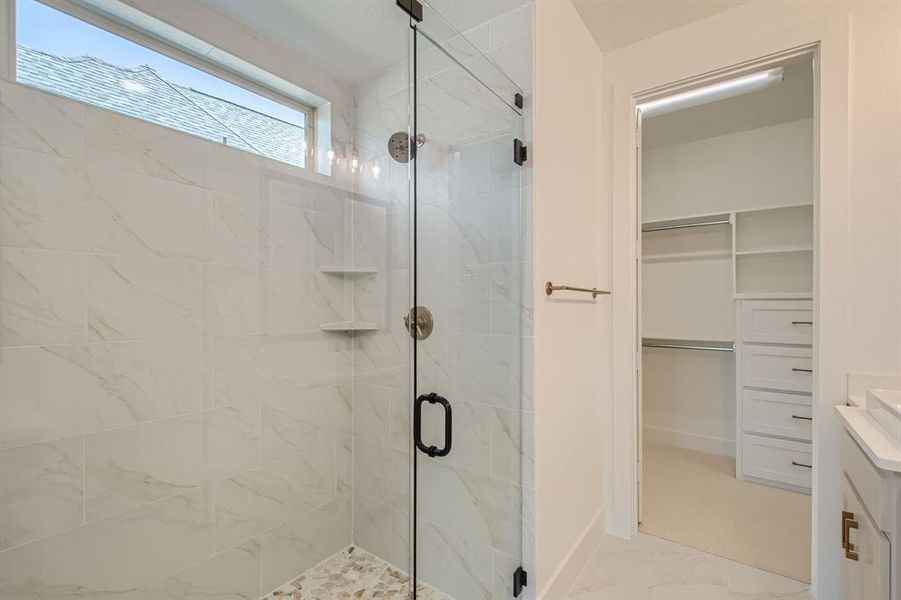 Bathroom with vanity and a shower with door