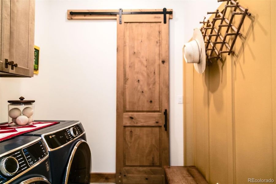 Full sized washer dryer in mudroom near primary suite and garage; walk in closet behind the barn door.
