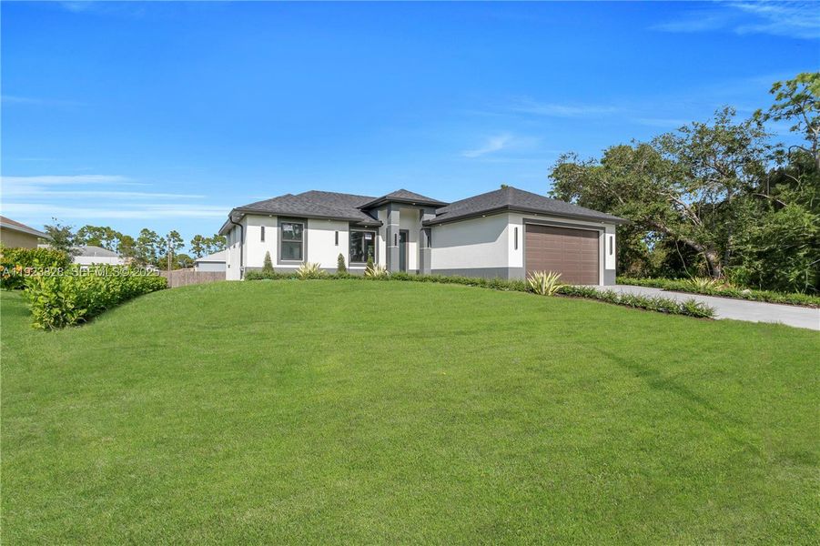 Front exterior of a new home in , Lehigh Acres, FL, highlighting curb appeal (Image 26).