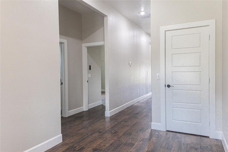 Unfurnished room featuring baseboards and dark wood-style floors Unfurnished room featuring baseboards and dark wood-style floors