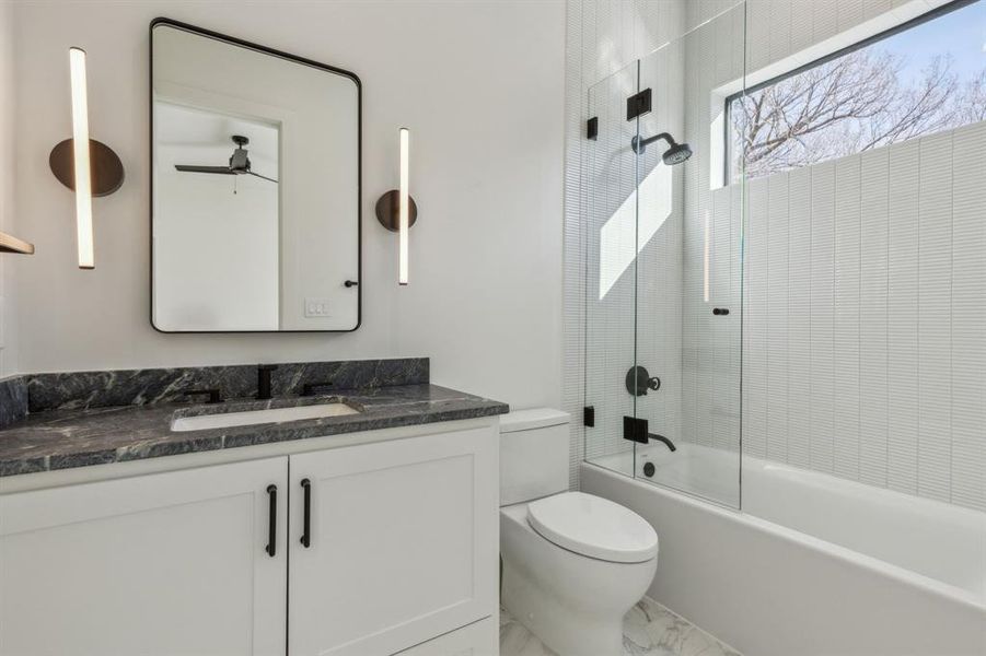 Full bathroom with ceiling fan, toilet, vanity, and bathtub / shower combination